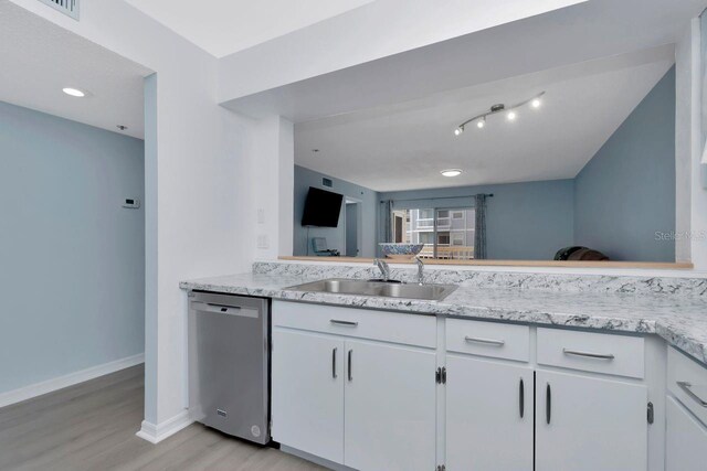 6817 Stones Throw Cir N Unit 17203, Saint Petersburg, FL 33710 - kitchen with stainless steel dishwasher, a sink, light wood-type flooring, baseboards, and white cabinetry