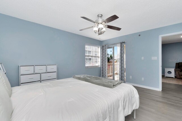 6817 Stones Throw Cir N Unit 17203, Saint Petersburg, FL 33710 - bedroom featuring wood finished floors, access to exterior, baseboards, ceiling fan, and a textured ceiling