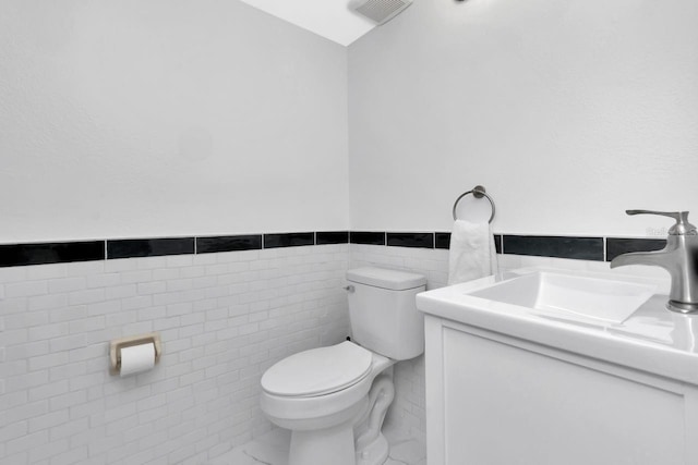 6817 Stones Throw Cir N Unit 17203, Saint Petersburg, FL 33710 - bathroom with toilet, tile walls, vanity, and a wainscoted wall
