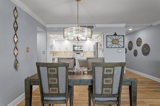 17920 Gulf Blvd Unit 1901, Redington Shores, FL 33708 - dining area featuring a chandelier, crown molding, baseboards, light wood-style flooring, and recessed lighting
