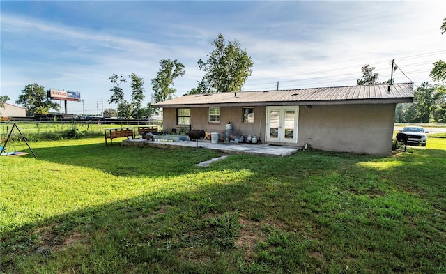 10818 Land O Lakes Blvd, Land O Lakes, FL 34638 - rear view of house with stucco siding, french doors, a patio, and metal roof