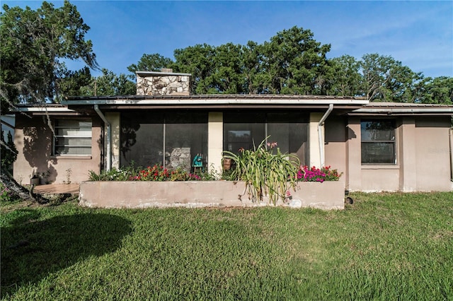 10818 Land O Lakes Blvd, Land O Lakes, FL 34638 - rear view of house with a yard, a chimney, a sunroom, and stucco siding