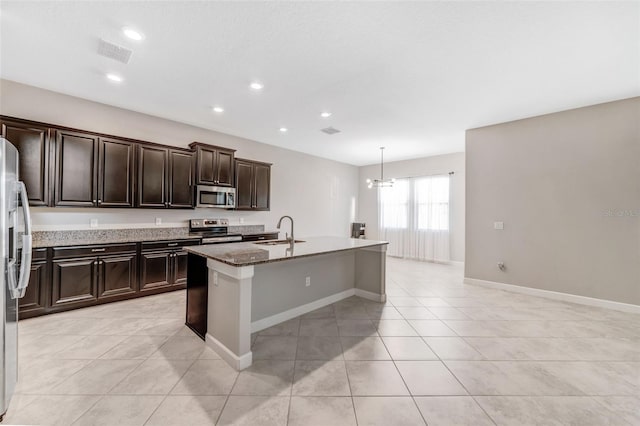 11726 Sunburst Marble Rd, Riverview, FL 33579 - kitchen with appliances with stainless steel finishes, a sink, a kitchen island with sink, light tile patterned floors, and dark stone counters