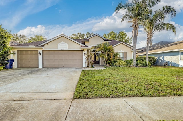 447 Bridle Path Way, Tarpon Springs, FL 34688 - view of front of home featuring stucco siding, a front lawn, an attached garage, and concrete driveway