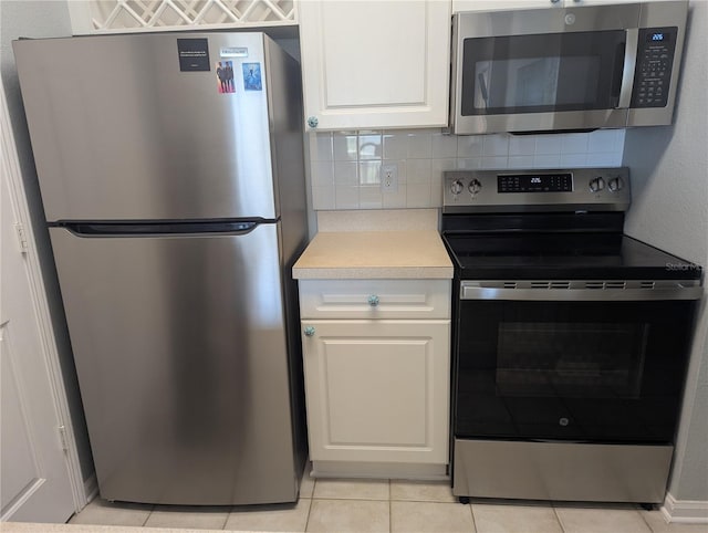 1216 S Missouri Ave Unit 223, Clearwater, FL 33756 - kitchen with stainless steel appliances, light countertops, backsplash, light tile patterned flooring, and white cabinets