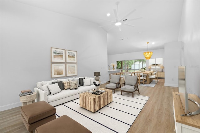 7644 Conrad St, Wesley Chapel, FL 33544 - living room with high vaulted ceiling, light wood finished floors, a ceiling fan, baseboards, and a chandelier