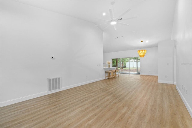 7644 Conrad St, Wesley Chapel, FL 33544 - unfurnished living room with high vaulted ceiling, ceiling fan, light wood-style flooring, a chandelier, and baseboards