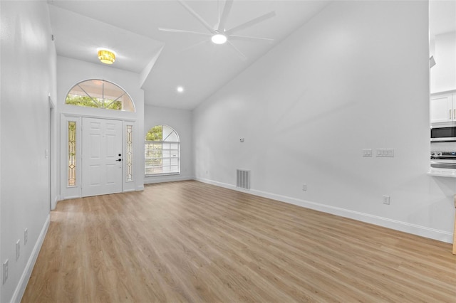 7644 Conrad St, Wesley Chapel, FL 33544 - foyer with high vaulted ceiling, a ceiling fan, light wood-type flooring, and baseboards