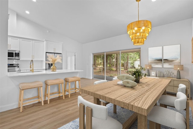 7644 Conrad St, Wesley Chapel, FL 33544 - dining area with a chandelier, light wood finished floors, high vaulted ceiling, recessed lighting, and baseboards
