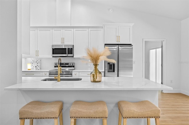 7644 Conrad St, Wesley Chapel, FL 33544 - kitchen with appliances with stainless steel finishes, white cabinetry, a breakfast bar, and a sink