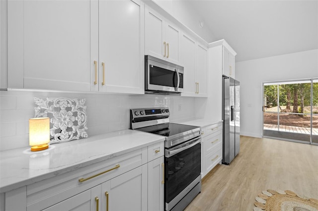 7644 Conrad St, Wesley Chapel, FL 33544 - kitchen with appliances with stainless steel finishes, light wood-style flooring, white cabinets, decorative backsplash, and light stone countertops