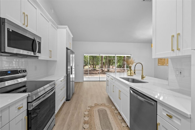 7644 Conrad St, Wesley Chapel, FL 33544 - kitchen with appliances with stainless steel finishes, a sink, white cabinets, and light wood-style floors