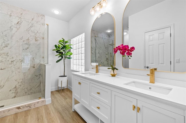 7644 Conrad St, Wesley Chapel, FL 33544 - bathroom featuring a marble finish shower, double vanity, wood finished floors, and baseboards