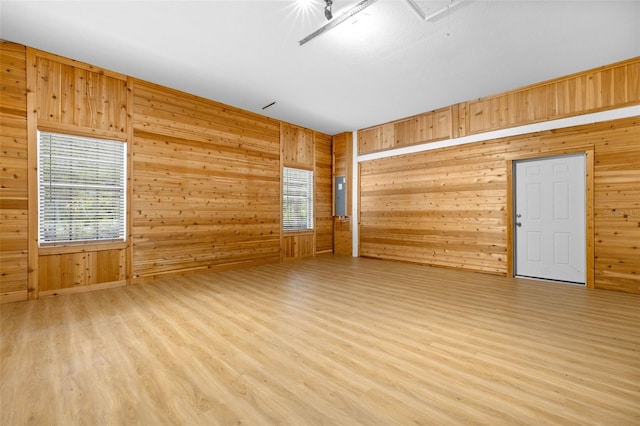 7644 Conrad St, Wesley Chapel, FL 33544 - empty room featuring light wood-style flooring, wooden walls, electric panel, and attic access