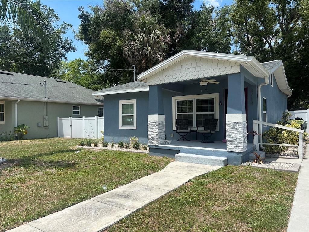 3718 N 36th St, Tampa, FL 33610 - view of front facade featuring a porch, ceiling fan, stucco siding, and stone siding