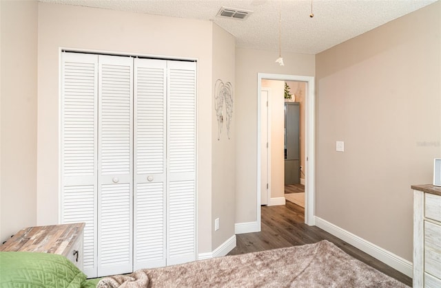 2403 Nantucket Field Way Unit 27, Sun City Center, FL 33573 - bedroom with a closet, baseboards, wood finished floors, and a textured ceiling