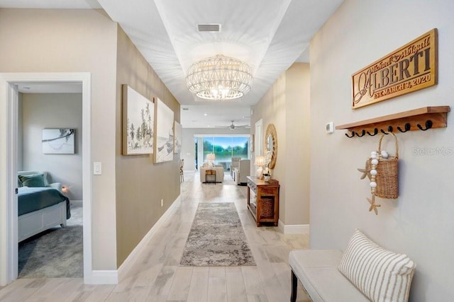 6097 Golden Nettle Dr, Apollo Beach, FL 33572 - hall featuring a chandelier, baseboards, and light wood-type flooring