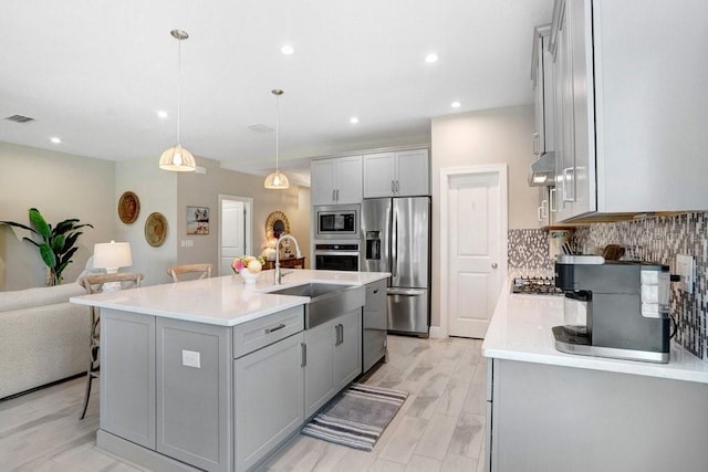 6097 Golden Nettle Dr, Apollo Beach, FL 33572 - kitchen featuring stainless steel appliances, gray cabinetry, a sink, light countertops, and a kitchen breakfast bar
