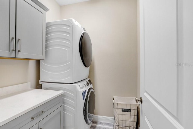 6097 Golden Nettle Dr, Apollo Beach, FL 33572 - laundry area featuring stacked washer / dryer, cabinet space, and baseboards