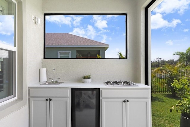 6097 Golden Nettle Dr, Apollo Beach, FL 33572 - indoor wet bar featuring stainless steel gas stovetop, beverage cooler, healthy amount of natural light, and a textured wall