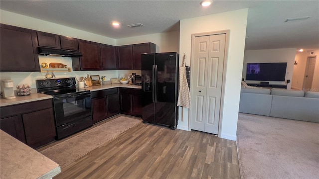 10123 Carp Hollow Rd, Sun City Center, FL 33573 - kitchen with black appliances, under cabinet range hood, dark brown cabinetry, light countertops, and open floor plan