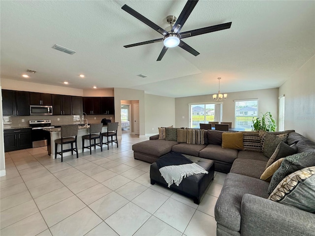 1509 Venice Ln, Davenport, FL 33896 - living room with healthy amount of natural light, light tile patterned floors, a chandelier, ceiling fan, and a textured ceiling