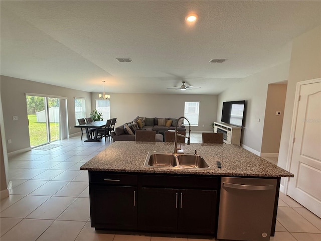 1509 Venice Ln, Davenport, FL 33896 - kitchen featuring a sink, stainless steel dishwasher, open floor plan, light stone countertops, and a textured ceiling