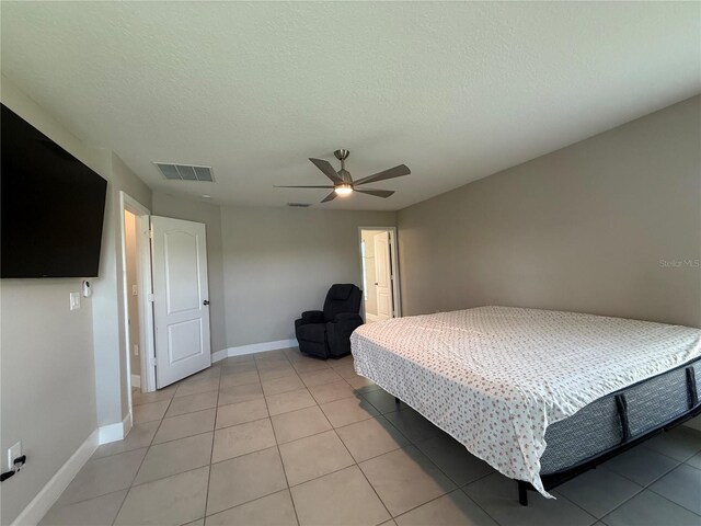 1509 Venice Ln, Davenport, FL 33896 - bedroom with light tile patterned floors, baseboards, a ceiling fan, and a textured ceiling