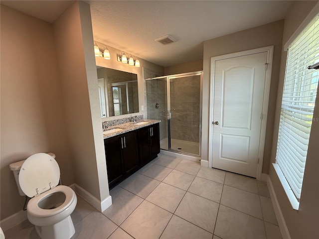 1509 Venice Ln, Davenport, FL 33896 - full bathroom with double vanity, tile patterned flooring, a shower stall, toilet, and baseboards