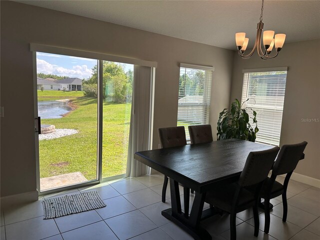 1509 Venice Ln, Davenport, FL 33896 - dining area with a chandelier, light tile patterned floors, a water view, and baseboards