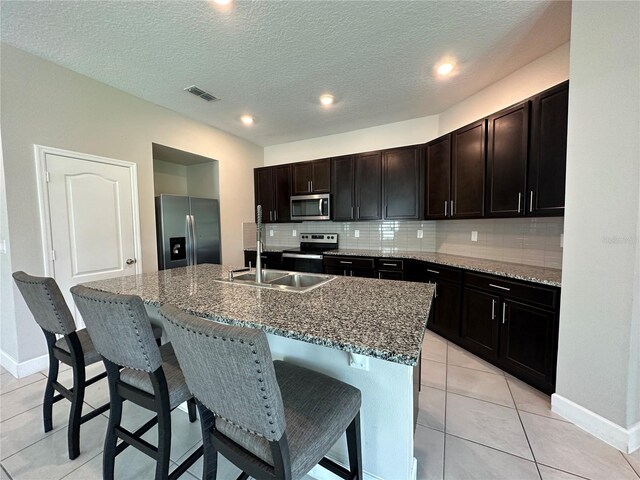 1509 Venice Ln, Davenport, FL 33896 - kitchen with stainless steel appliances, a sink, a breakfast bar area, tasteful backsplash, and recessed lighting