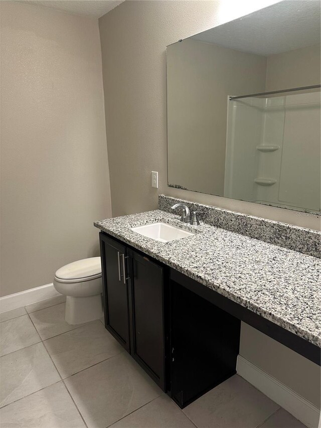 1509 Venice Ln, Davenport, FL 33896 - full bath featuring vanity, toilet, tile patterned flooring, baseboards, and a shower