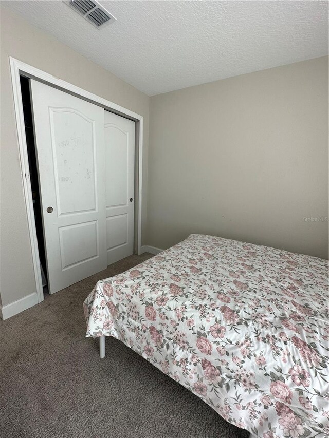 1509 Venice Ln, Davenport, FL 33896 - bedroom with carpet floors, a closet, baseboards, and a textured ceiling