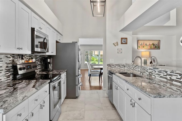 11927 Steppingstone Blvd, Tampa, FL 33635 - kitchen featuring stainless steel appliances, a sink, tasteful backsplash, a peninsula, and white cabinets