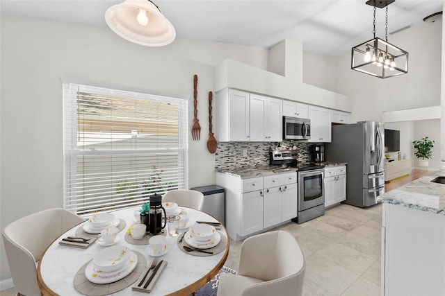 11927 Steppingstone Blvd, Tampa, FL 33635 - kitchen with appliances with stainless steel finishes, tasteful backsplash, white cabinetry, light stone countertops, and pendant lighting