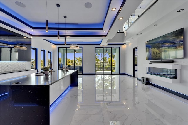 6530 Simone Shores Cir, Apollo Beach, FL 33572 - kitchen featuring marble tiled flooring, open floor plan, a raised ceiling, and modern cabinets