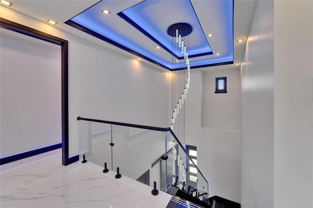 6530 Simone Shores Cir, Apollo Beach, FL 33572 - stairway featuring a tray ceiling, recessed lighting, marble tiled floors, and baseboards