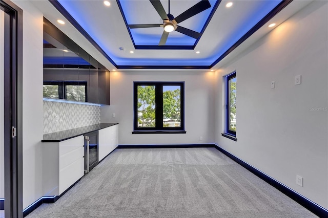 6530 Simone Shores Cir, Apollo Beach, FL 33572 - spare room featuring light carpet, wine cooler, a tray ceiling, a ceiling fan, and baseboards