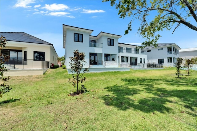 6530 Simone Shores Cir, Apollo Beach, FL 33572 - back of property with a balcony, a yard, and stucco siding