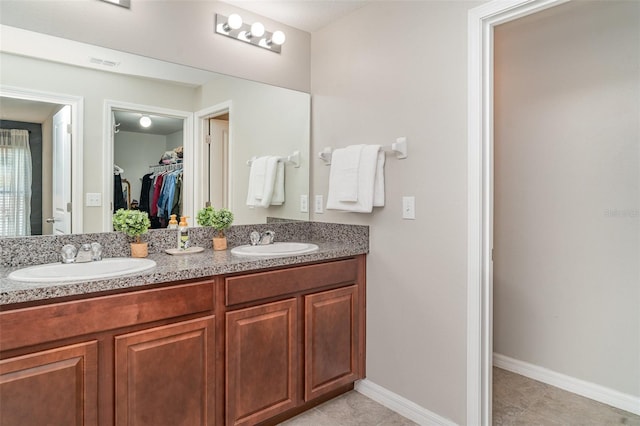 10104 Carloway Hills Dr, Wimauma, FL 33598 - full bath featuring double vanity, a spacious closet, tile patterned flooring, and baseboards