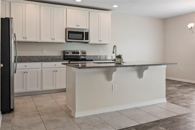 12170 Gothic Rd, Spring Hill, FL 34610 - kitchen featuring appliances with stainless steel finishes, white cabinetry, dark stone countertops, recessed lighting, and a sink