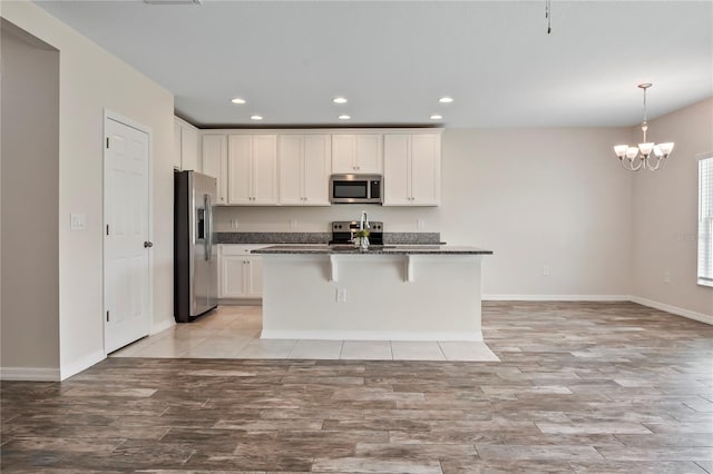 12170 Gothic Rd, Spring Hill, FL 34610 - kitchen with appliances with stainless steel finishes, light wood finished floors, baseboards, white cabinetry, and recessed lighting