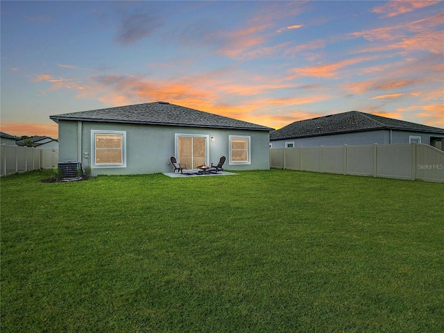 12170 Gothic Rd, Spring Hill, FL 34610 - back of house at dusk with stucco siding, central air condition unit, and a shingled roof