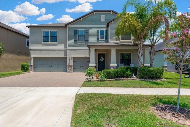 11612 Sunburst Marble Rd, Riverview, FL 33579 - craftsman-style house with a garage, driveway, a front yard, stone siding, and a porch