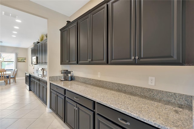 11612 Sunburst Marble Rd, Riverview, FL 33579 - kitchen featuring light tile patterned floors, white microwave, light stone counters, recessed lighting, and baseboards