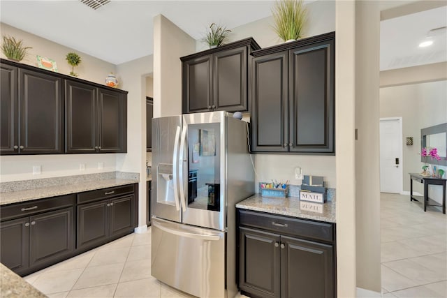 11612 Sunburst Marble Rd, Riverview, FL 33579 - kitchen with stainless steel fridge with ice dispenser, light tile patterned floors, and light stone counters