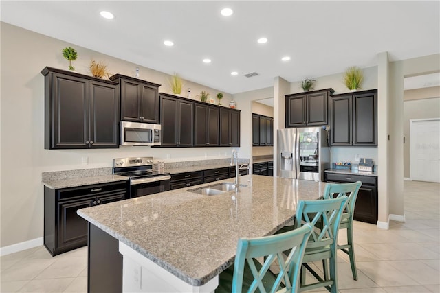 11612 Sunburst Marble Rd, Riverview, FL 33579 - kitchen featuring stainless steel appliances, a sink, light tile patterned floors, a center island with sink, and recessed lighting