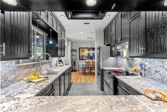 213 N Hesperides St, Tampa, FL 33609 - kitchen featuring range with electric stovetop, a sink, dark cabinets, under cabinet range hood, and light stone countertops