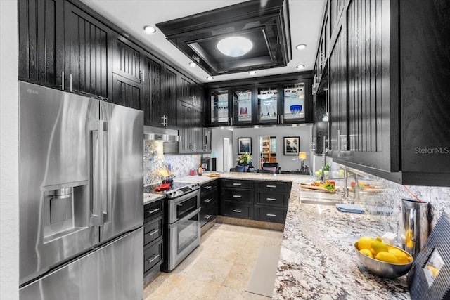 213 N Hesperides St, Tampa, FL 33609 - kitchen with stainless steel appliances, dark cabinets, backsplash, a tray ceiling, and a sink