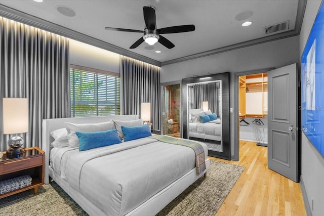 213 N Hesperides St, Tampa, FL 33609 - bedroom with a walk in closet, light wood finished floors, crown molding, and a ceiling fan